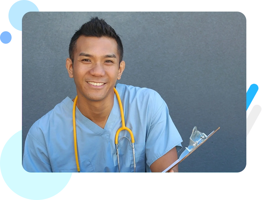 A young man in scrubs holding a clipboard.